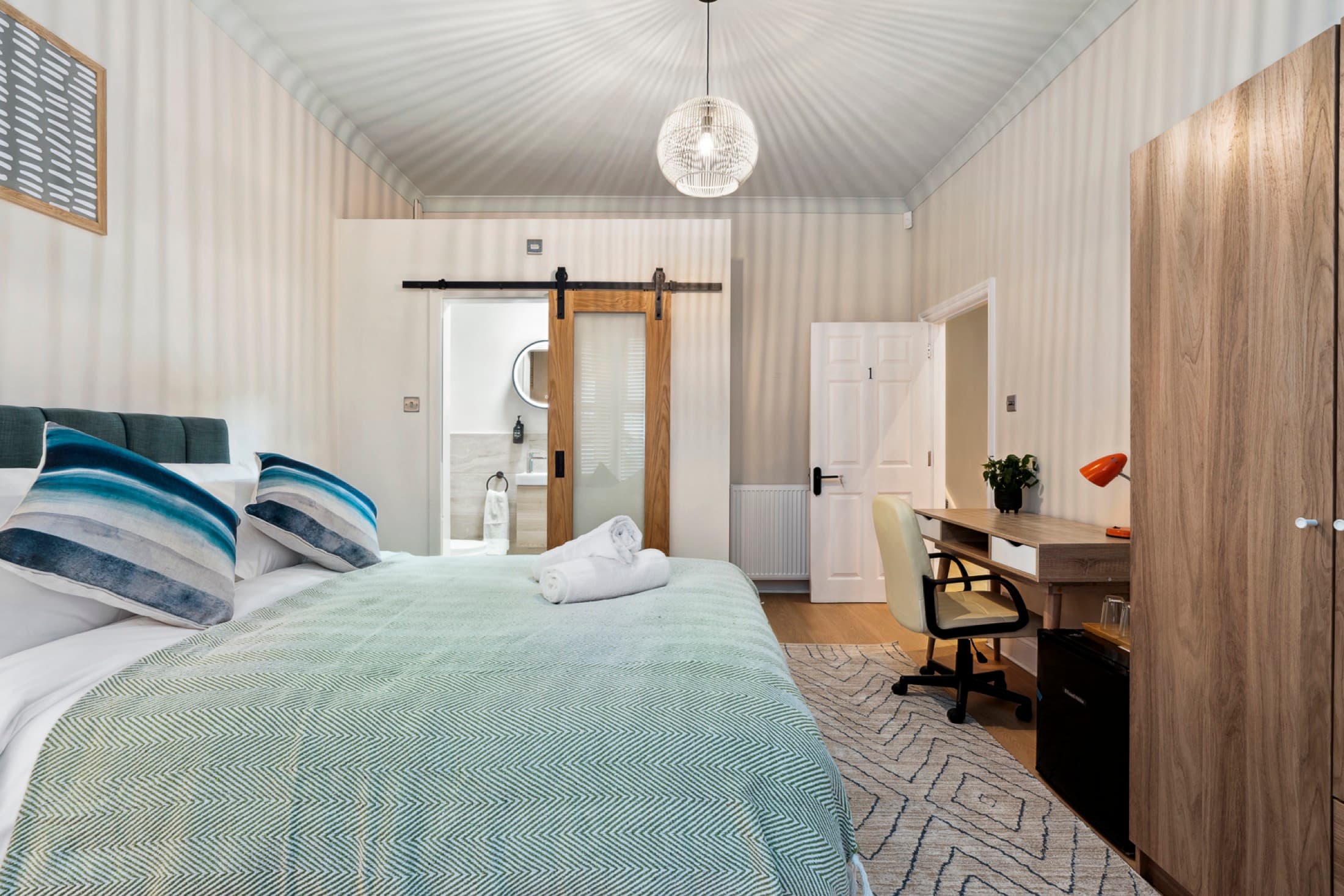 Neutral-toned serviced bedroom with storage and workspace